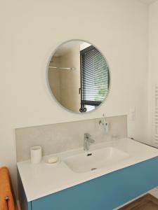 a bathroom with a white sink and a mirror at Au Bon Cap in Hervelinghen +1 photo