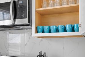a row of blue coffee mugs in a cupboard at Dormont, Pittsburgh !A Spacious and Modern Private Bedroom with Shared Bathroom in Pittsburgh