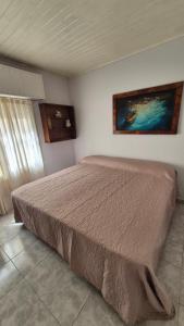 a bed in a bedroom with a painting on the wall at Betania in Carhué