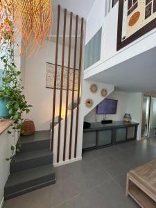 a staircase in a living room with a tv at Coeur Créole in Saint Barthelemy