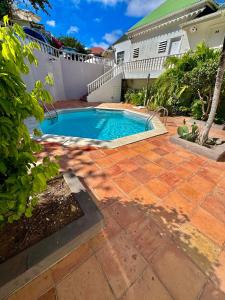 a swimming pool in a yard next to a house at Coeur Créole in Saint Barthelemy