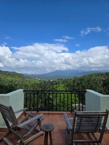 two chairs sitting on a balcony with a view at mountain retreat villa in Kandy