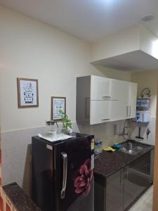 a kitchen with a black refrigerator and a sink at 2 BHK Apartment, Jalandhar in Jalandhar