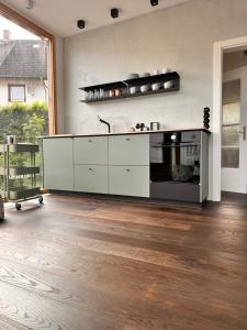 a kitchen with a white counter and a fireplace at HAUS AM SEE - Natur Pur in Friedenweiler