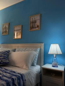 a blue bedroom with a bed and a table with a lamp at Al Bastione B&B in Barletta