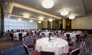 a banquet hall with white tables and chairs and lights at Hilton London Tower Bridge in London