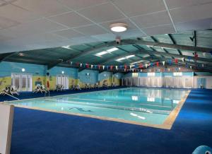 a large swimming pool in a large building at Norfolk Beach Chalet - California Sands Resort in Great Yarmouth
