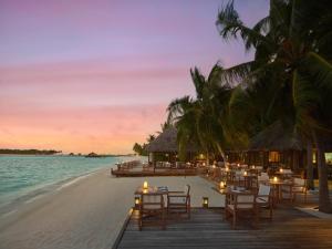 a restaurant on the beach at sunset at Conrad Maldives Rangali Island in Mandhoo