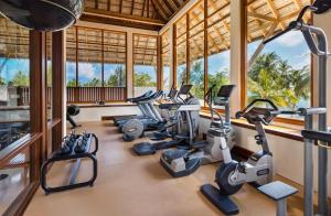 a gym with a row of treadmills and elliptical machines at Conrad Maldives Rangali Island in Mandhoo