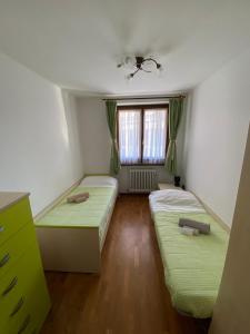 a room with two beds and a window at Rosadira Vista Lago sulle Dolomiti in Auronzo di Cadore
