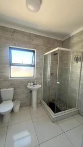 a bathroom with a shower and a toilet and a sink at CasaLisa beach House in Langstrand