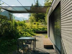 a patio with a table and chairs next to a building at cabinski Montafon in Sankt Gallenkirch