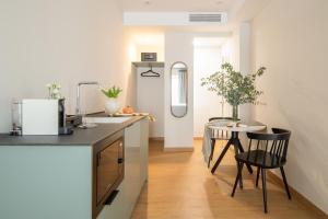 a kitchen with a counter and a table with chairs at Casa Carver 1927 by Hommyhome in Seville
