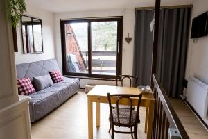 a living room with a couch and a table at Appartement 1 chambre terrasse et piscine in Boersch