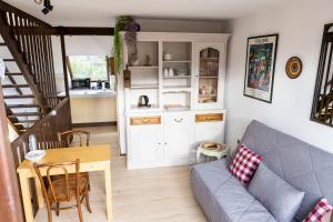 a living room with a couch and a table at Appartement 1 chambre terrasse et piscine in Boersch