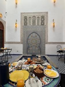 a table with plates of food on it in a room at Riad Mira in Fez