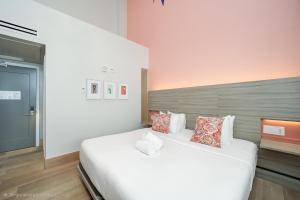 a bedroom with a large white bed with pillows at The Julia Hotel in Miami Beach