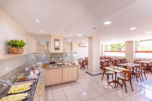 a restaurant with tables and chairs and a buffet at Hotel Suárez Executive Novo Hamburgo in Novo Hamburgo +47 photos