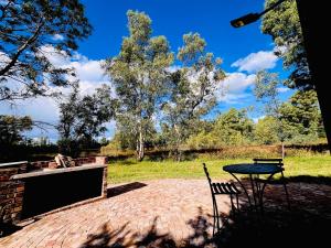 a table and a chair sitting on a brick patio at Lake Cabin in Olifantshoek +8 photos