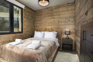 a bedroom with a bed with two towels on it at LF Parnassos Chalet in Eptalofos +33 photos