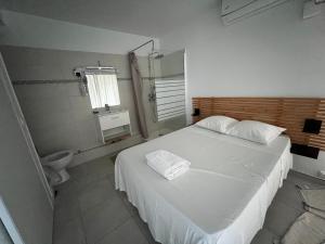 a bedroom with a white bed and a toilet at Le Loft in Pointe-à-Pitre