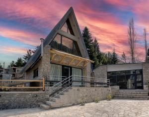 a house with a sunset in the background at LF Parnassos Chalet in Eptalofos