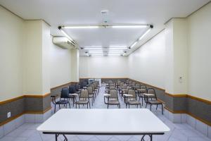 a room with rows of tables and chairs at Hotel Suárez Executive Novo Hamburgo in Novo Hamburgo