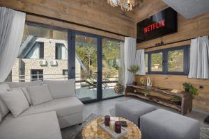 a living room with a couch and a table at LF Parnassos Chalet in Eptalofos