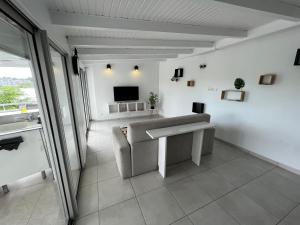 a living room with a table and a tv at Le Loft in Pointe-à-Pitre +2 photos