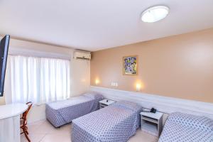 a hospital room with two chairs and a table at Hotel Suárez Executive Novo Hamburgo in Novo Hamburgo