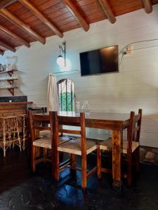 a dining room with a table and a tv on the wall at Posada de Nono in Nono