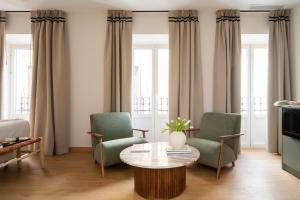 a living room with two chairs and a coffee table at Casa Carver 1927 by Hommyhome in Seville +66 photos