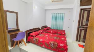 a bedroom with a red bed and a blue chair at Hotel Grand Nuria in Habiganj