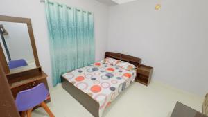 a bedroom with a bed and a dresser and a mirror at Hotel Grand Nuria in Habiganj