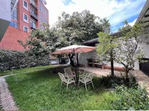 a patio with two chairs and an umbrella in the grass at Cuenca Hotel Apartment in Cuenca