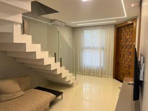 a living room with a staircase and a bed at Mansão Duplex Santarém in Santarém