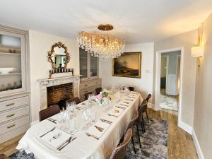 a dining room with a long table and a chandelier at Landguard - Yarmouth in Yarmouth