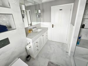 a white bathroom with a sink and a mirror at Landguard - Yarmouth in Yarmouth +38 photos