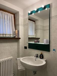 a bathroom with a sink and a mirror at Rosadira Vista Lago sulle Dolomiti in Auronzo di Cadore +12 photos