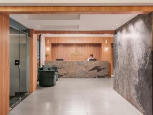 a lobby with a man standing at the reception desk at Hotel Farol da Ilha in Florianópolis +18 photos