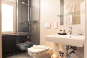 a bathroom with a sink and a toilet and a shower at OSTKÜSTE - Villa Albatros Design Apartments in Ahlbeck +52 photos