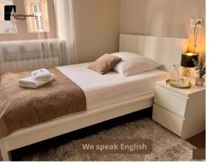 a bedroom with a bed with two towels on it at Apartamenty Przemyśl in Przemyśl