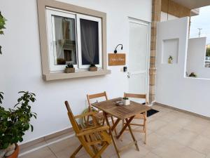 a table and chairs in a room with windows at Irene’s house in Koskinou