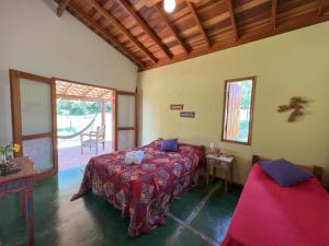 a bedroom with a bed in a room with a window at Pousada & Chalés Quinta da Nascente - Serra da Canastra in Delfinópolis +71 photos