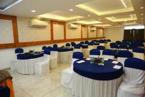 a banquet hall with blue and white tables and chairs at SoonStay Konark Inn in Indore