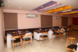 a dining room with tables and chairs in it at SoonStay Konark Inn in Indore
