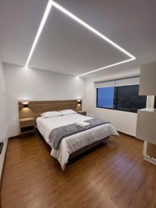 a bedroom with a bed and a large window at Cuenca Hotel Apartment in Cuenca