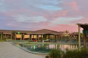 a resort with a swimming pool at dusk at Condominio Uhane Luxury Villas in São Miguel do Gostoso