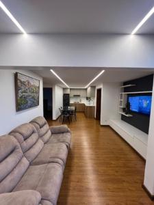 a living room with a couch and a flat screen tv at Cuenca Hotel Apartment in Cuenca