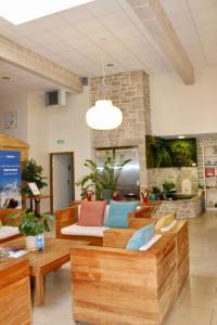 a lobby with couches and tables in a building at Brit Hotel Alghotel in Cancale